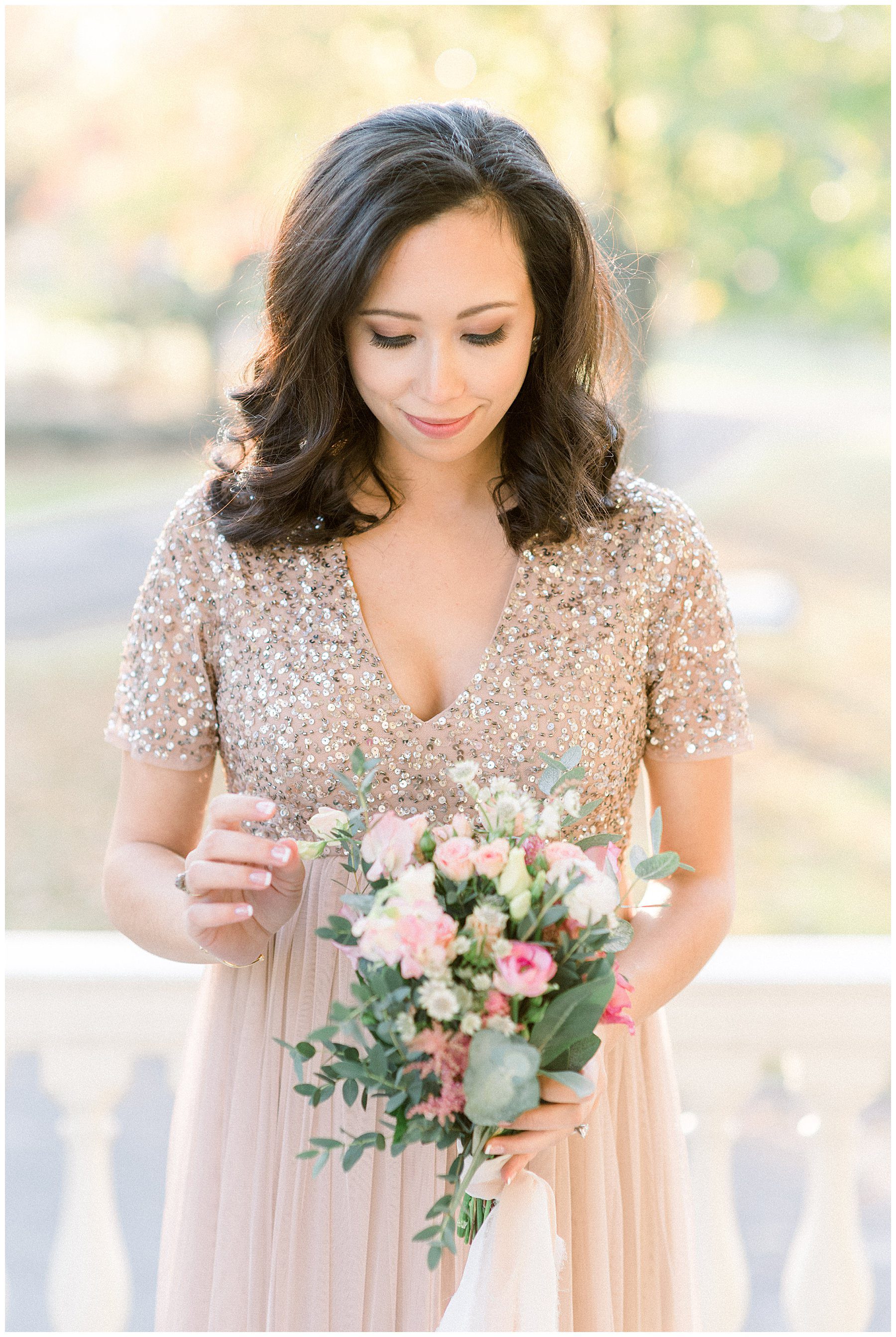 woman holds blush pink and ivory flower arrangement