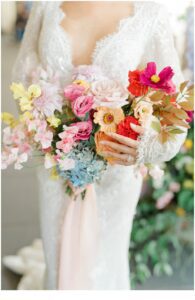 bride holds vibrant summer wedding bouquet