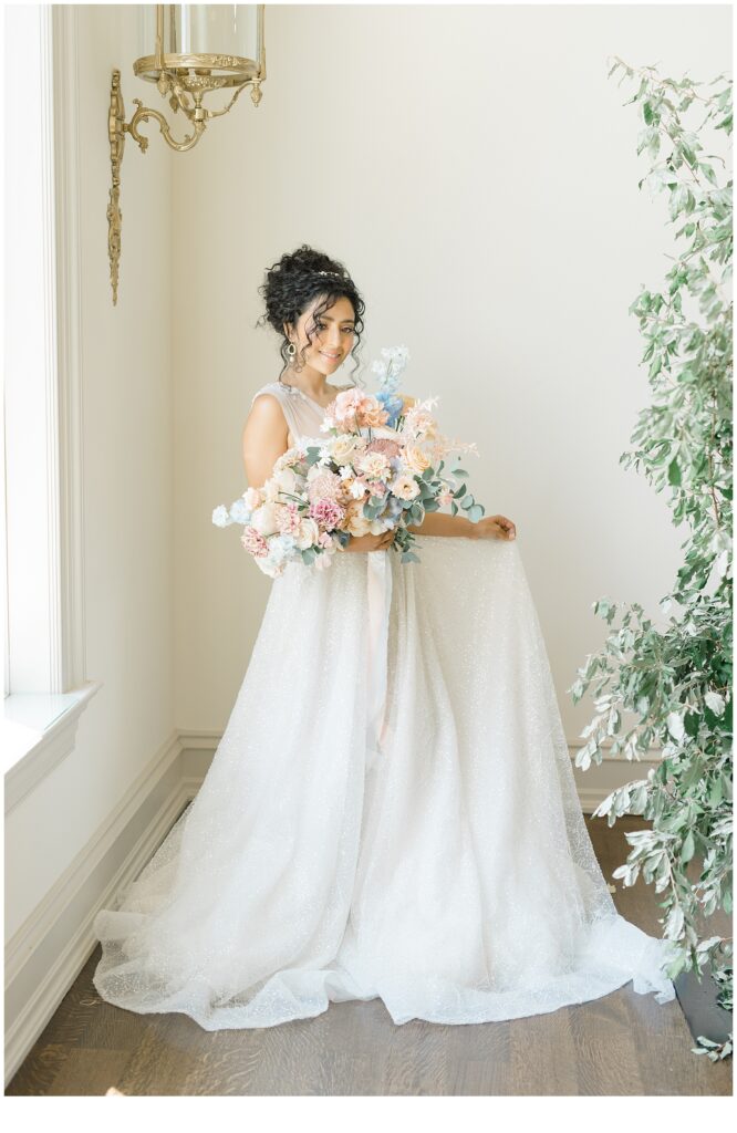bride in dress holding stunning flower arrangement