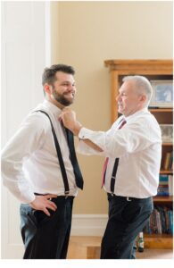 groom gets help with his tie