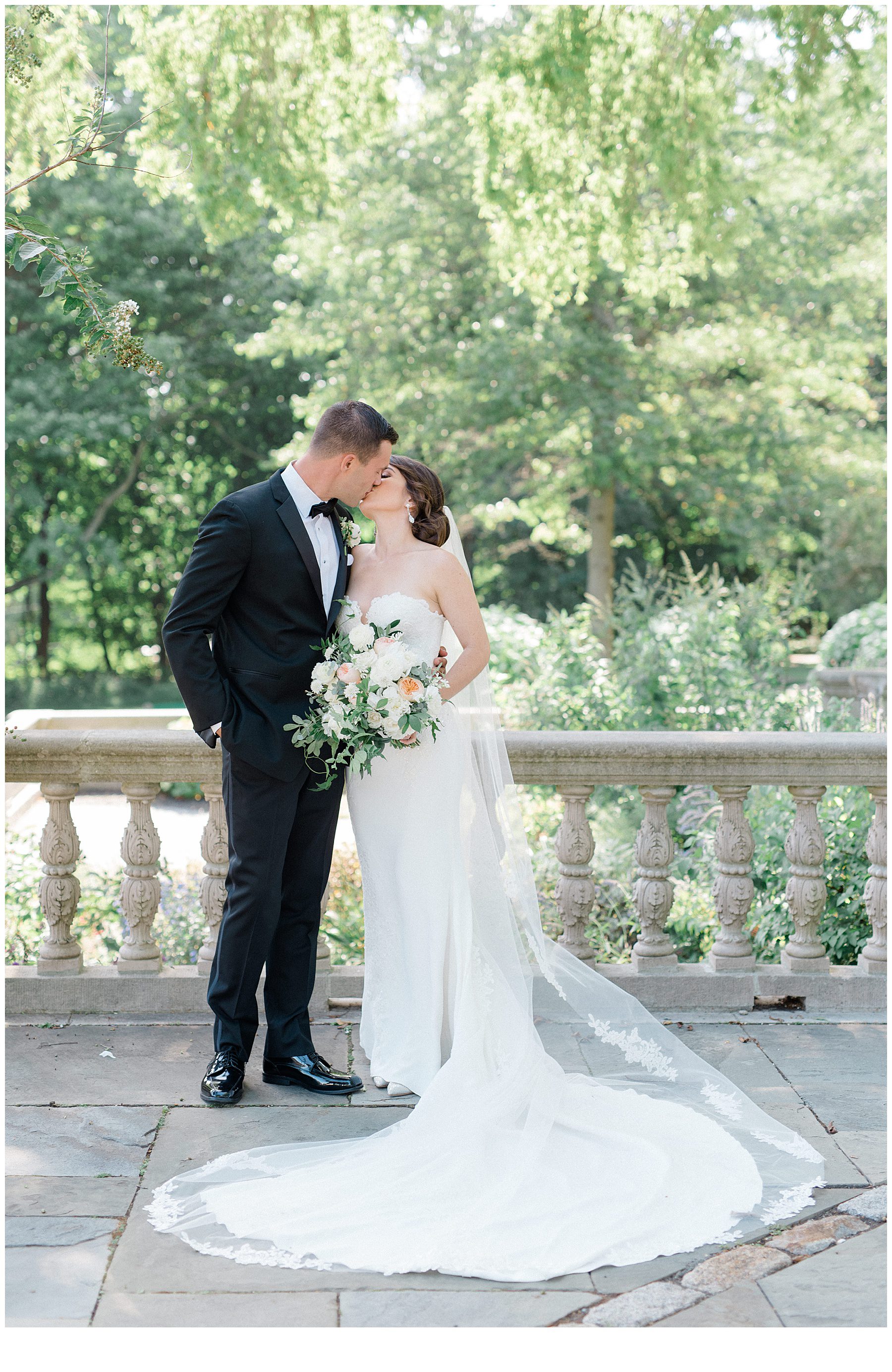 bride and groom kiss outside Curtis Arboretum in Wyncote, Pennsylvania