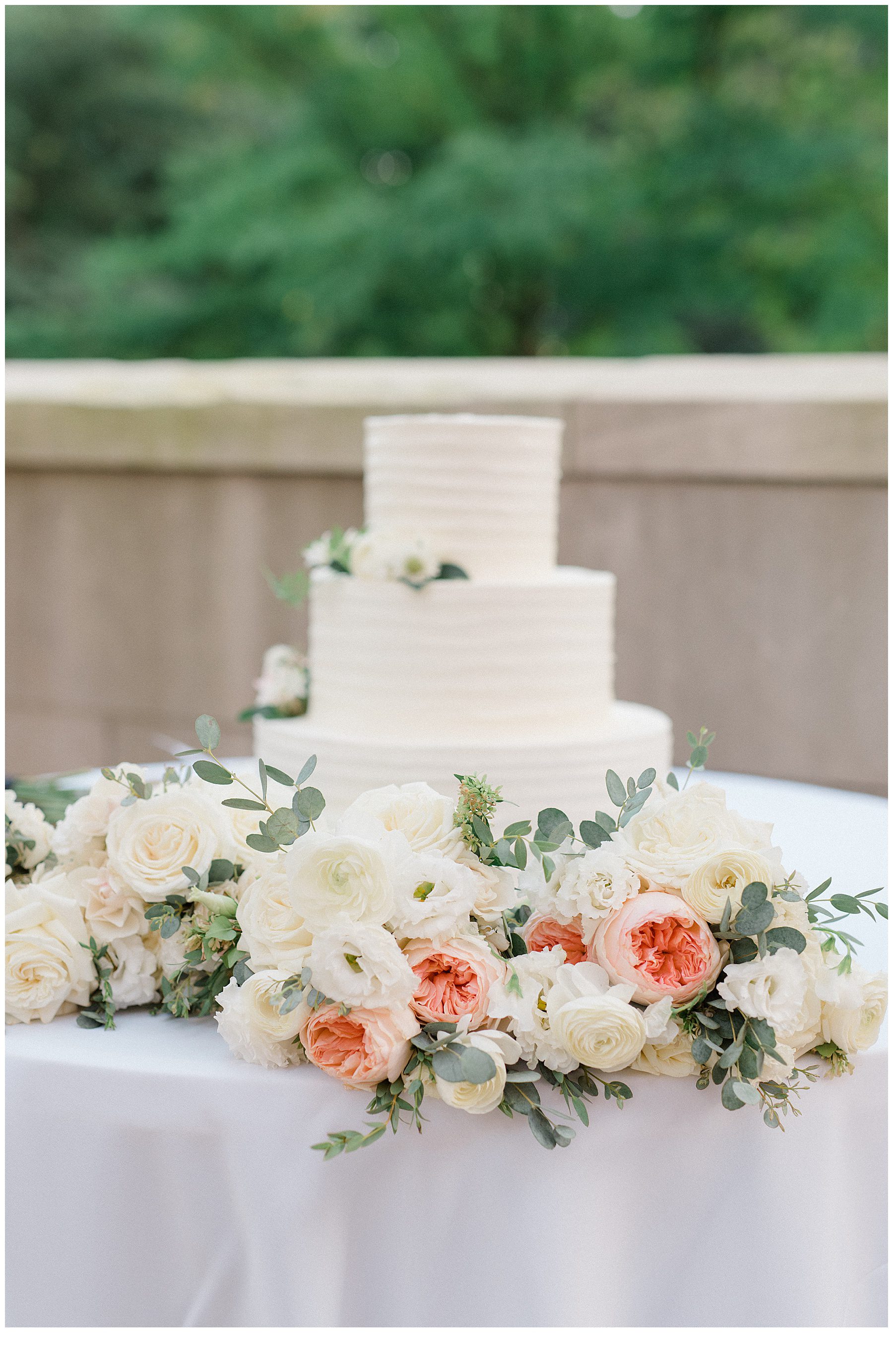 classic white wedding cake with white and peach flowers