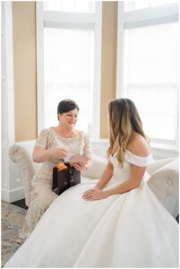 bride gives mom a gift on wedding day