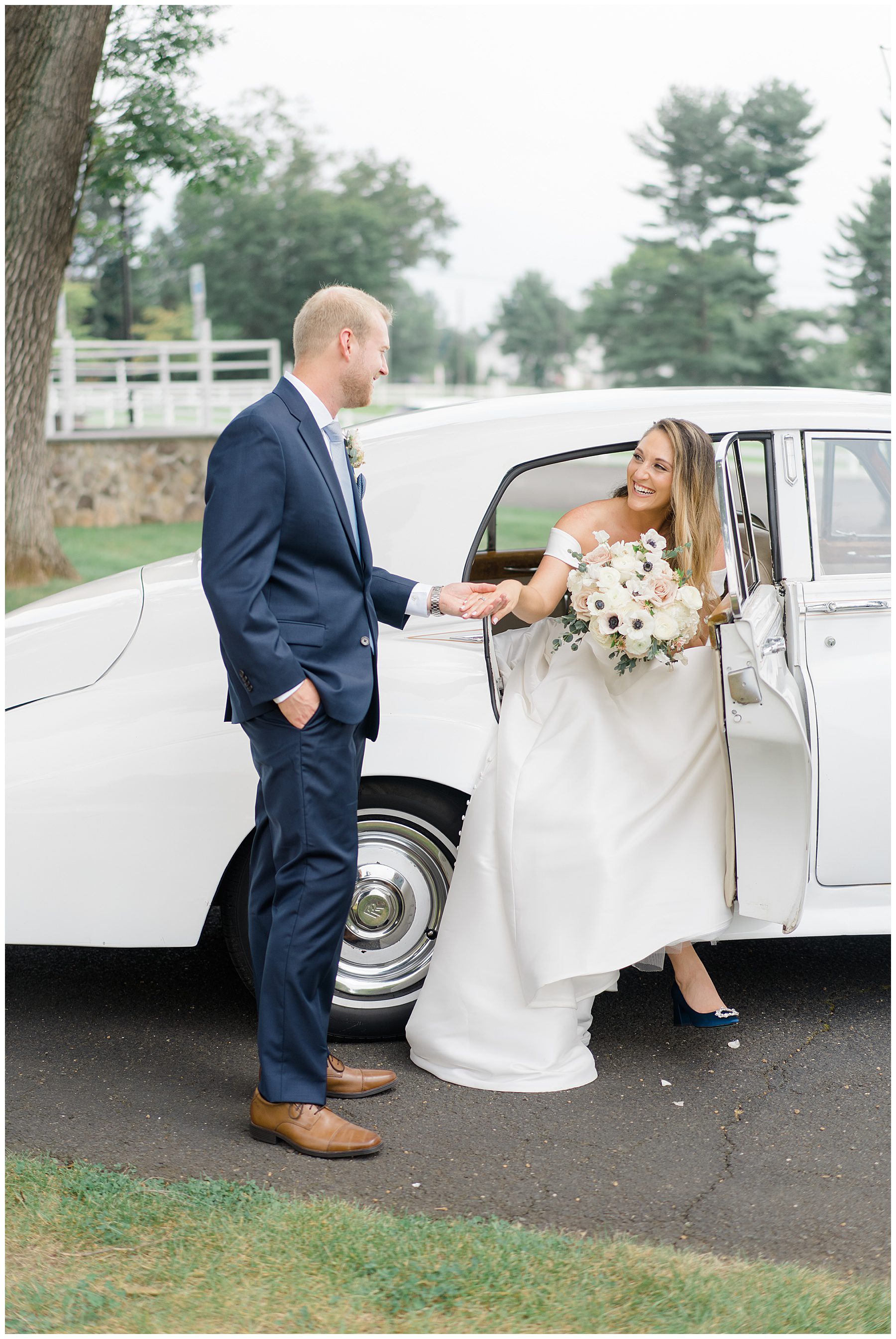 groom helps bride get out of rolls Royce