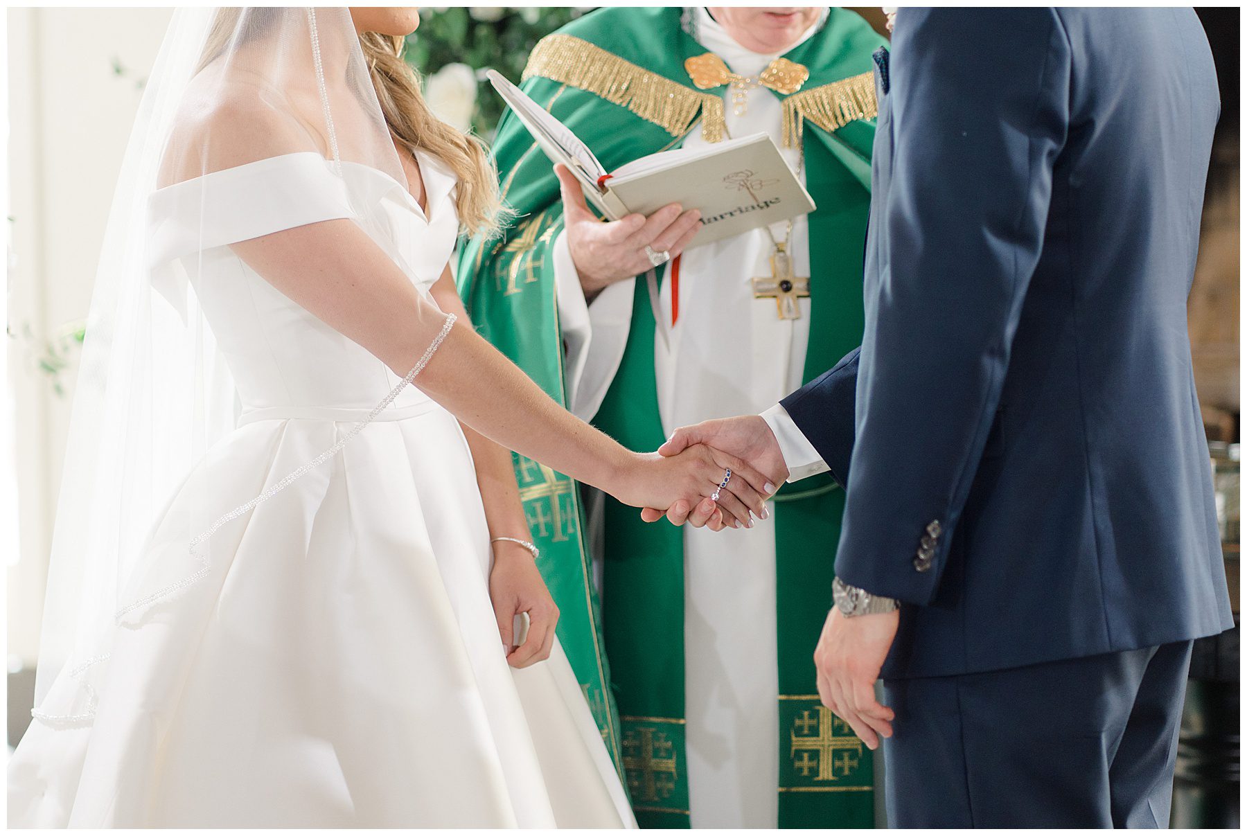 couple hold hands during wedding ceremony