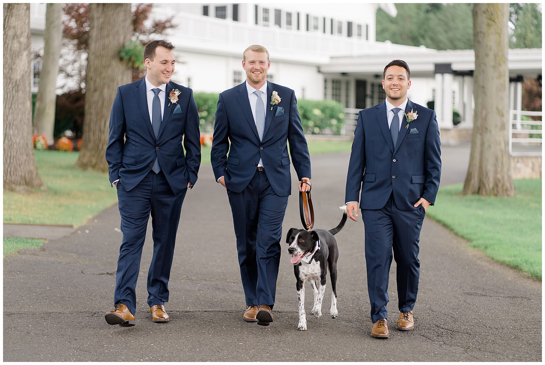 groom and groomsmen walk with dog
