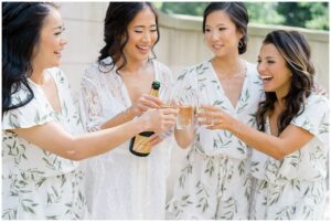 bride and bridesmaids toast with champagne