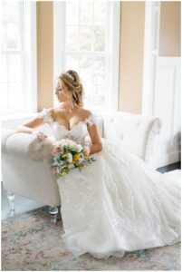 bride sits on couch in bridal suite