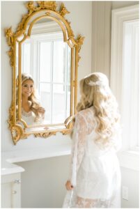 Bride looking in mirror in bridal suite