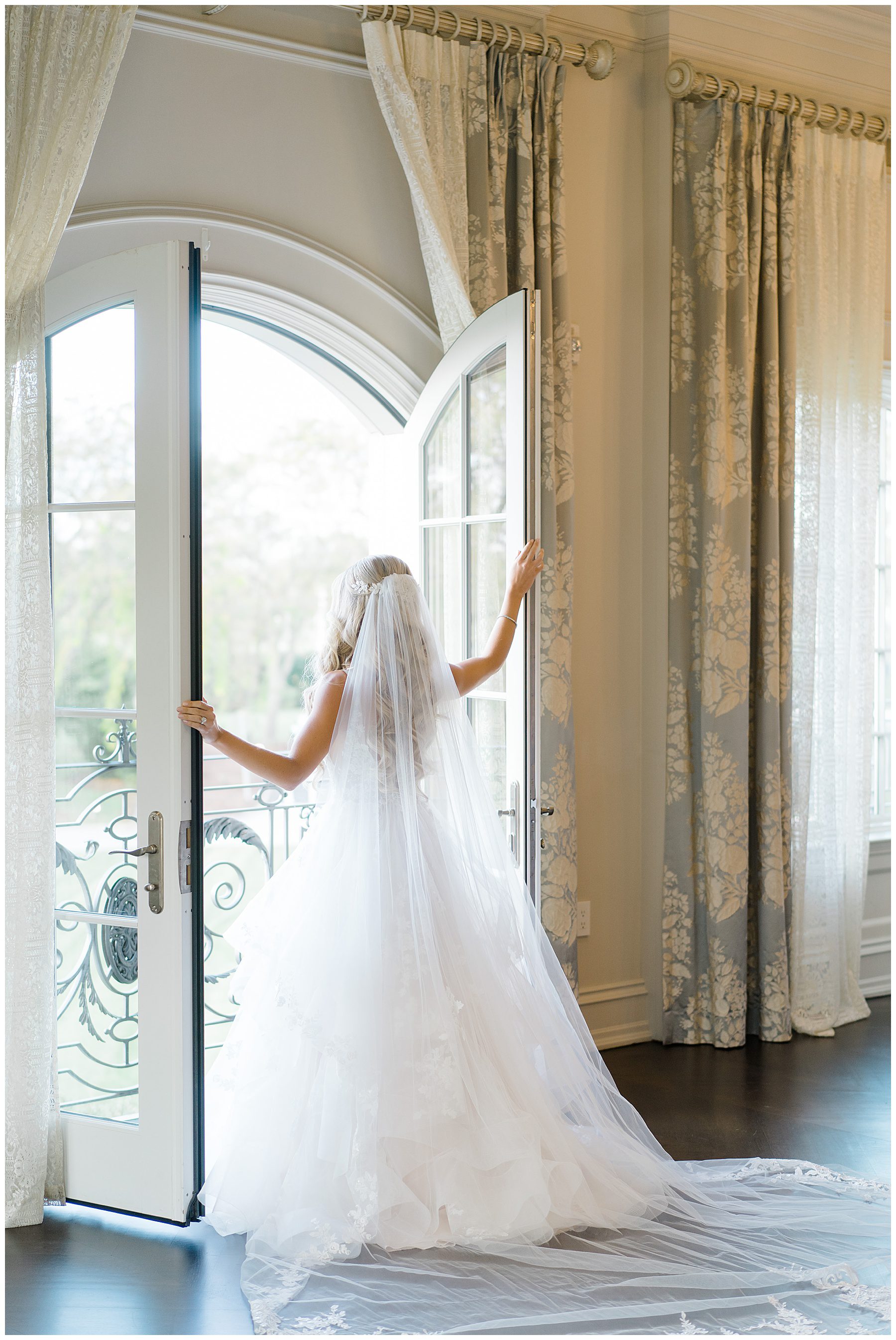 Bride looking out the balcony doors in bridal suite