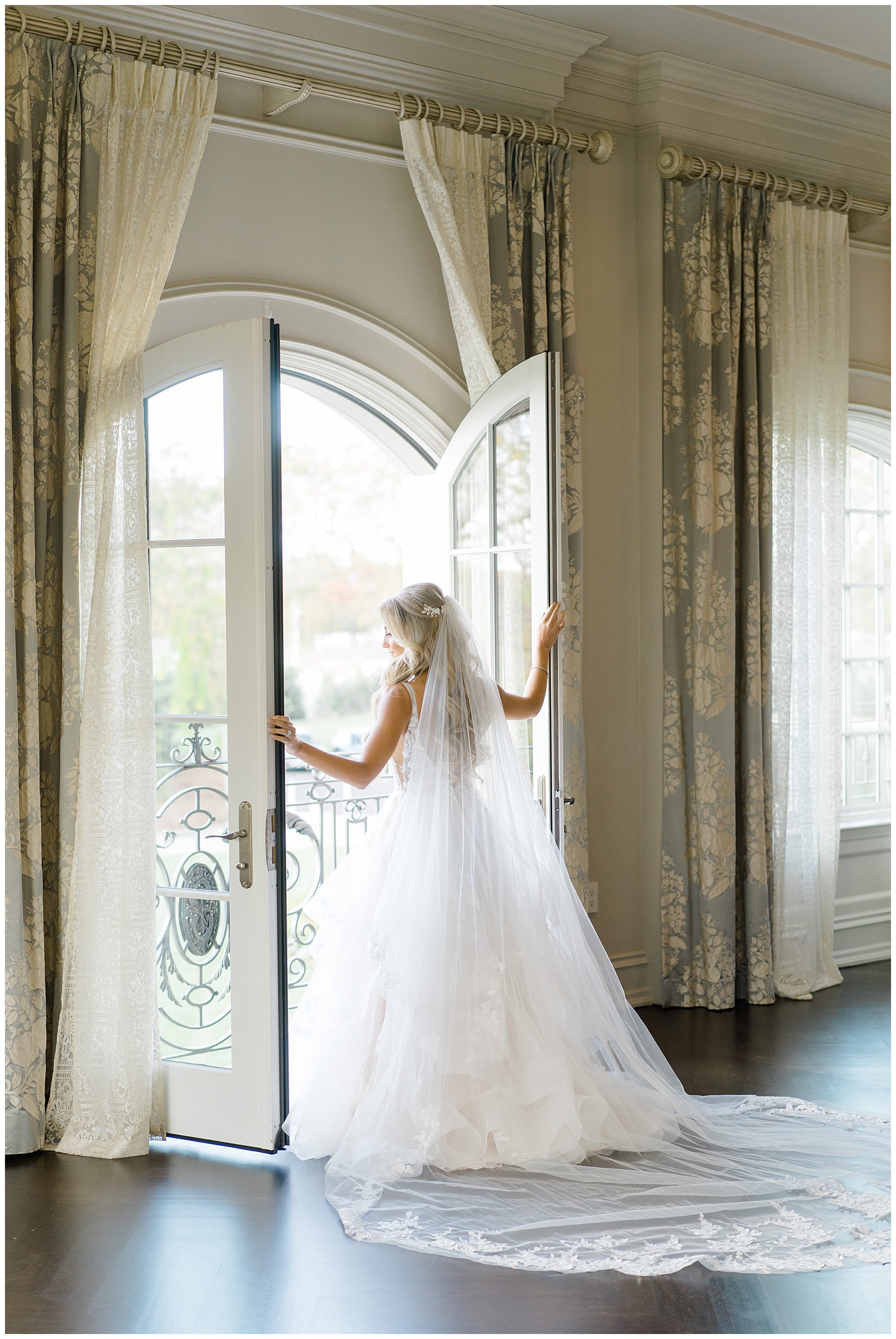 Bride looking out balcony doors of bridal suite before Park Chateau Fall Wedding