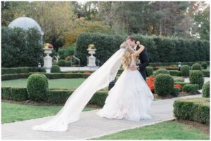 bride's veil flows behind her during first look outside of Park Chateau in NJ