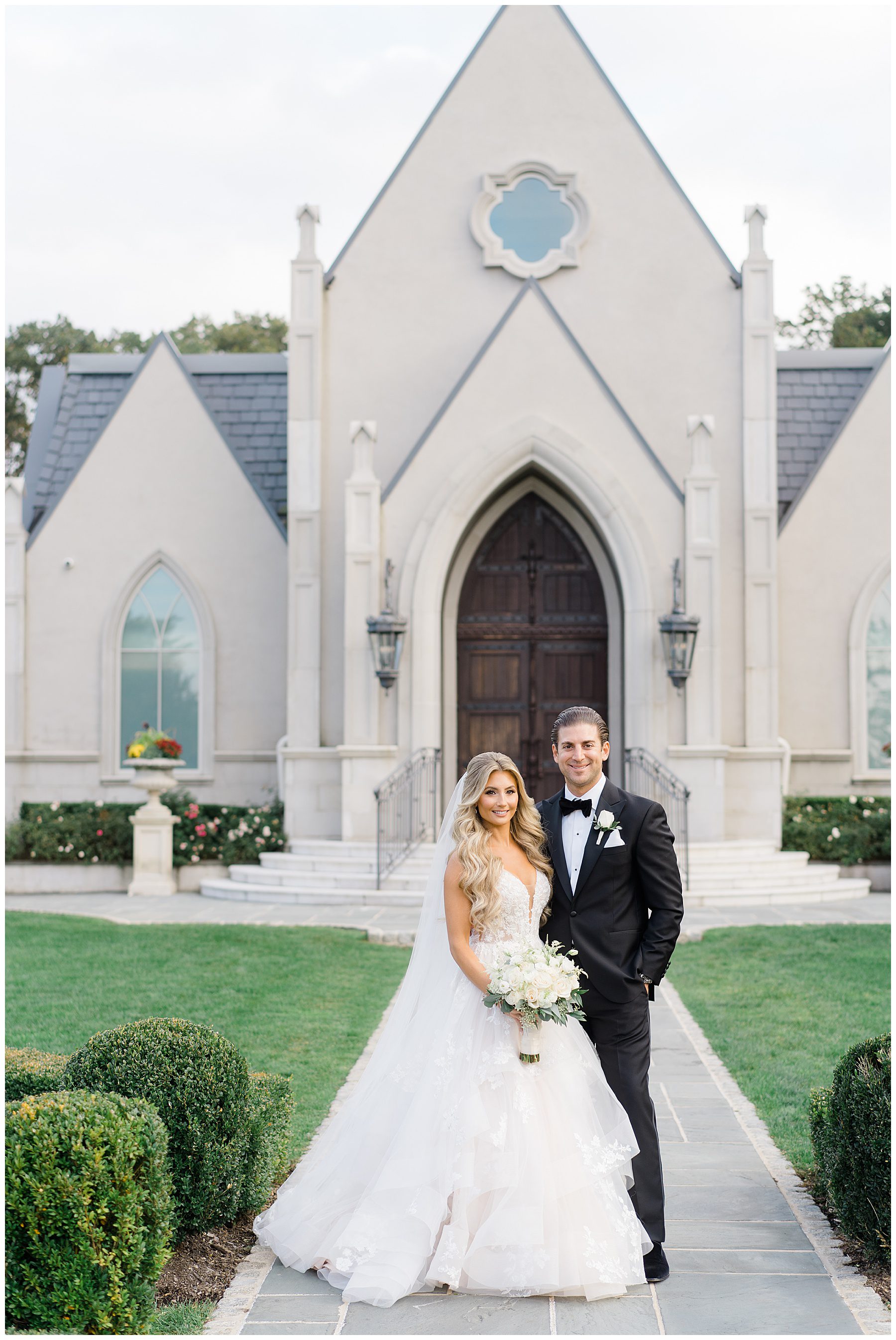 Bride and groom pose in front of chapel