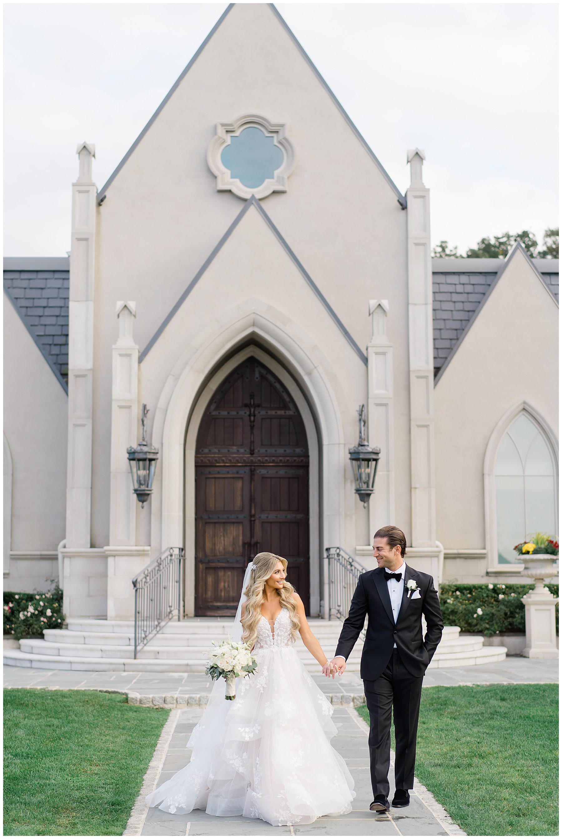 Bride and groom walk in front of chapel