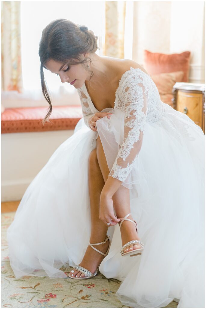 bride puts on wedding shoes before Elegant Cairnwood Estate Wedding