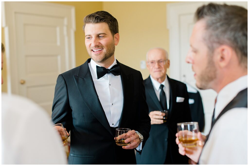 groom and groomsmen share toast before wedding