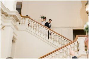 bride and groom walking down grand staircase of the Elegant Cairnwood Estate