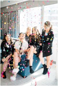 bride and bridesmaids celebrate with confetti
