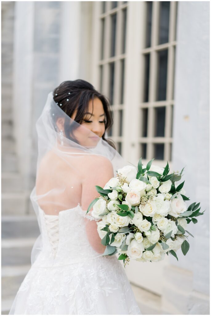 bride with veil and white classic wedding bouquet