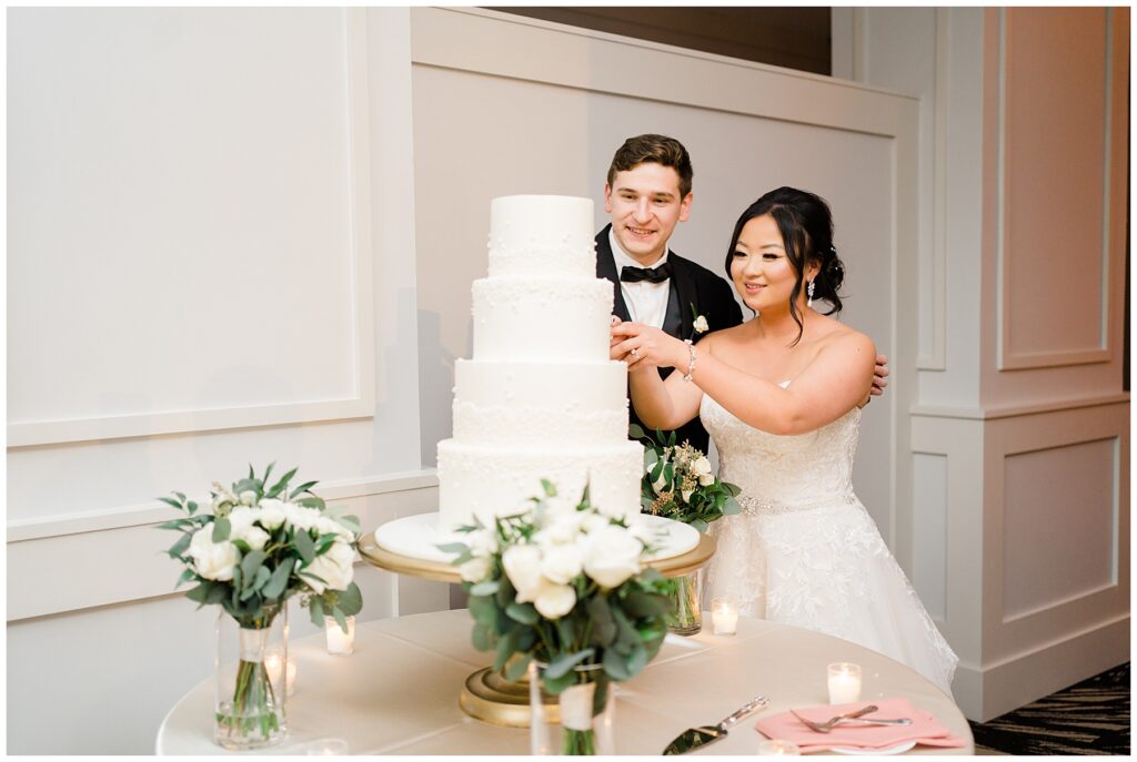 couple cut their cake at Winter Wedding at The Lucy by Cescaphe