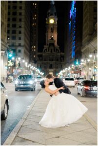 newlyweds kiss at night in downtown Philadelphia