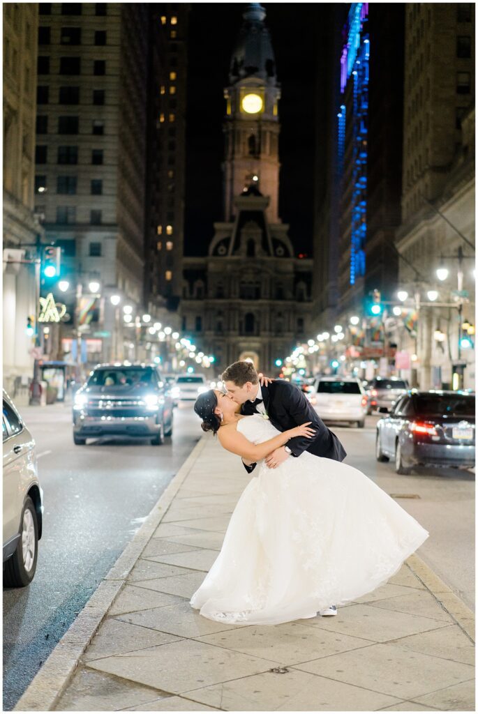 newlyweds kiss at night in downtown Philadelphia