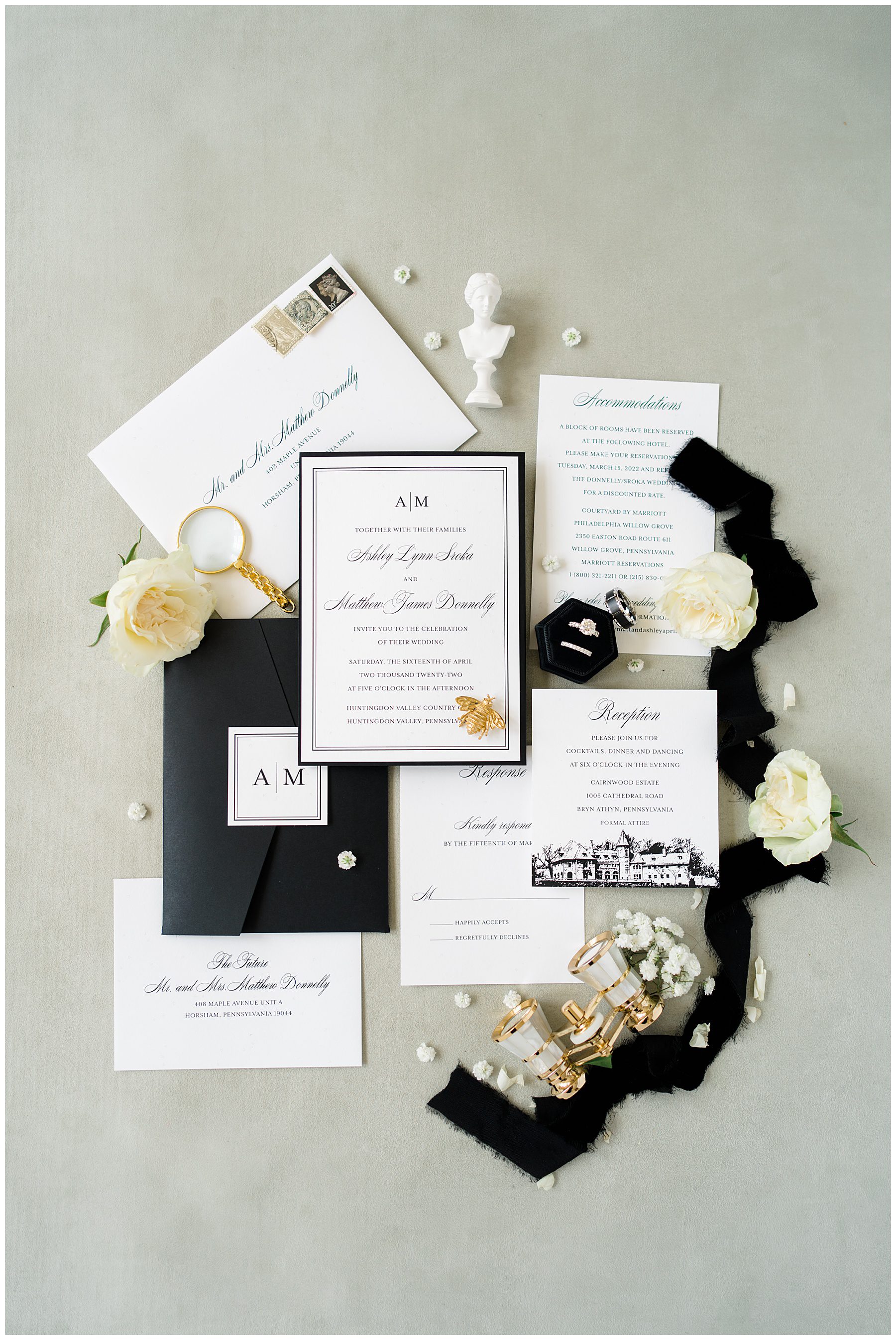 Classic black and white wedding invitation styled with white flowers and black ribbon