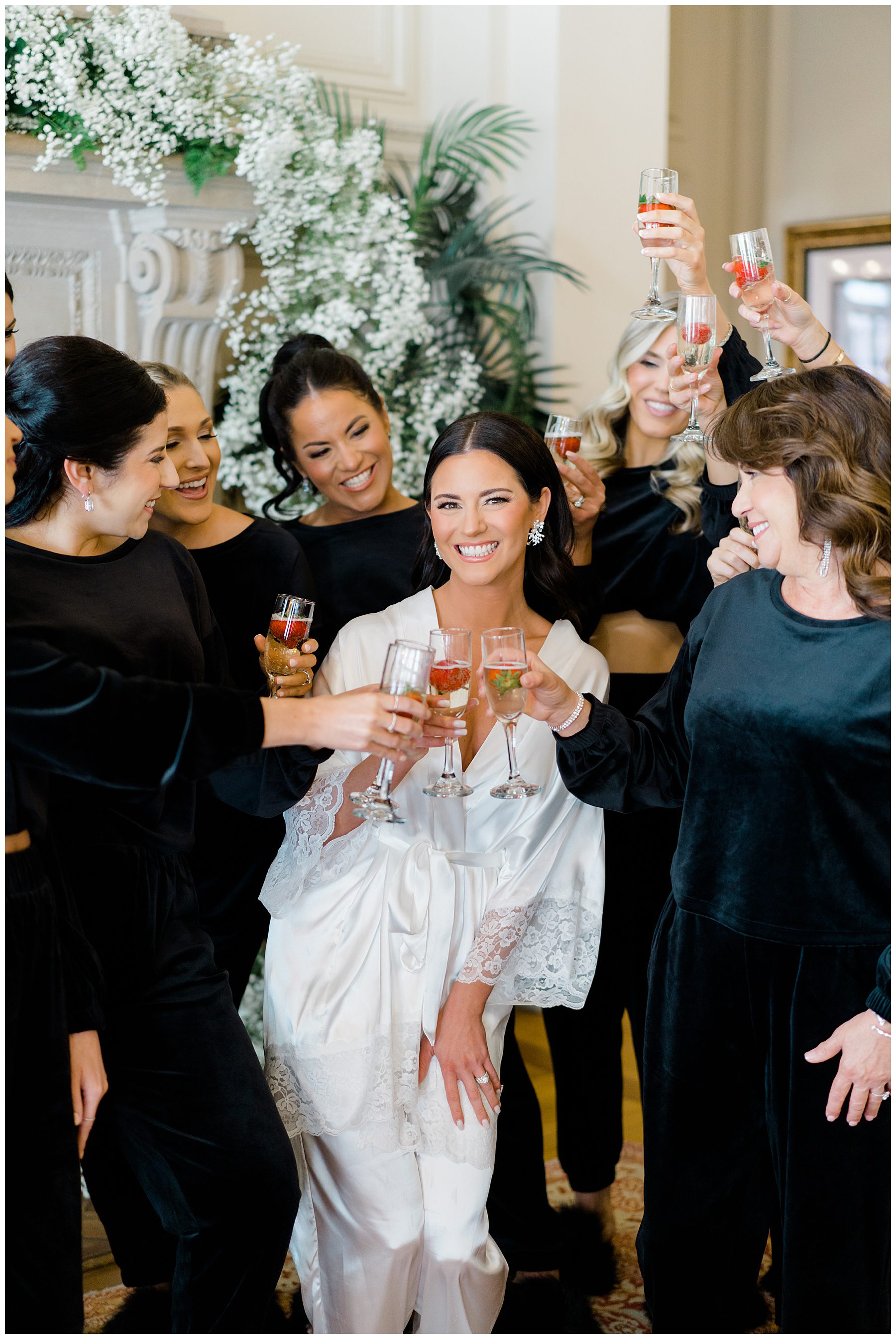 bride and bridesmaids toast while getting ready