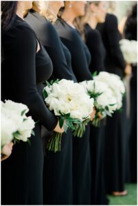 bridesmaids in black dresses and white flower bouquets