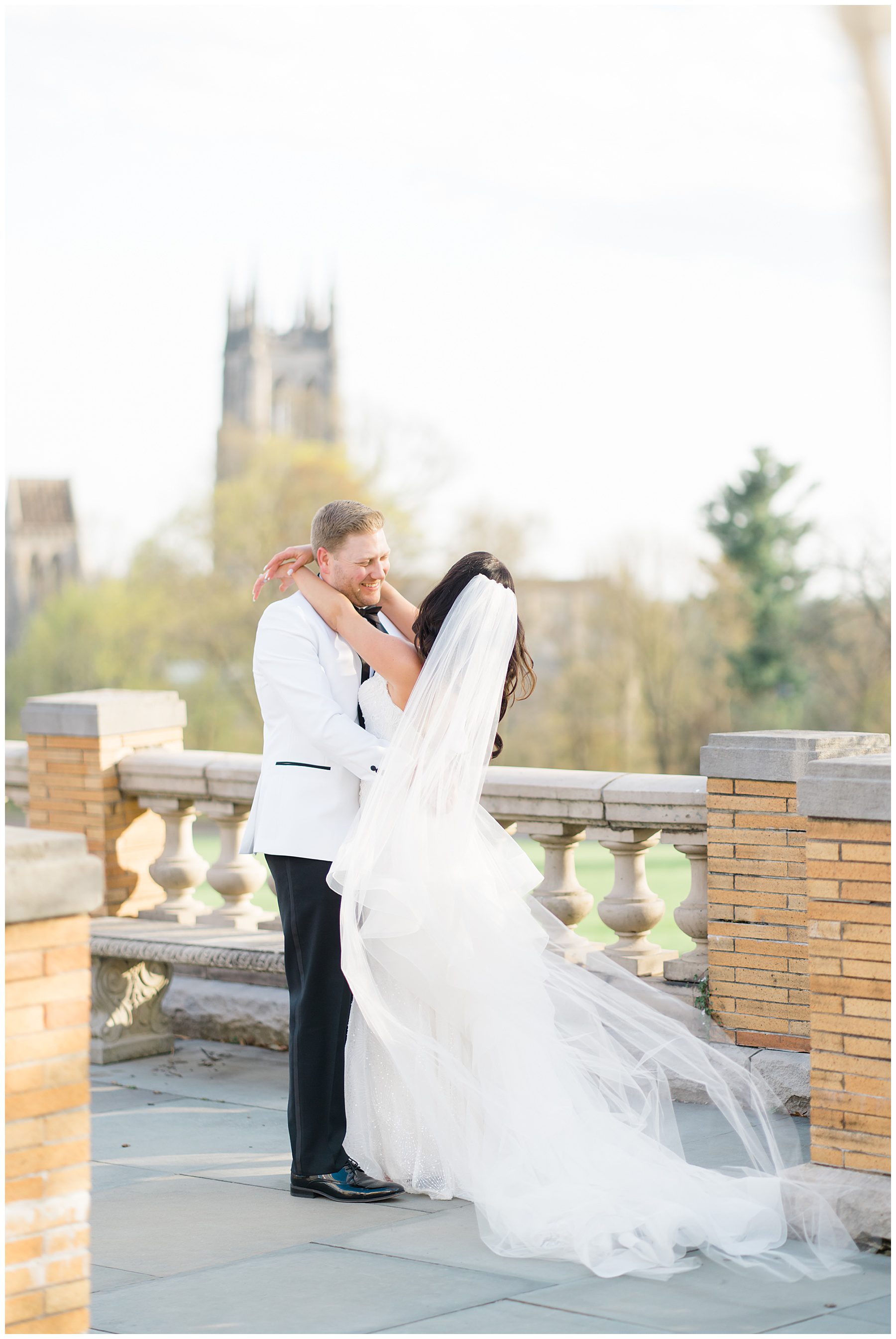 newlyweds on the balcony of Cairnwood Estate in Bryn Athyn, PA