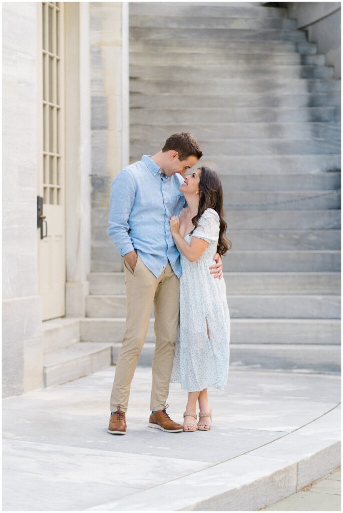 Woman and man embracing and smiling at one another for engagement photos