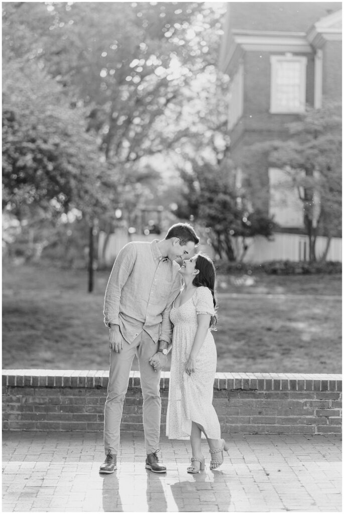 Black and white photo of engaged couple kissing