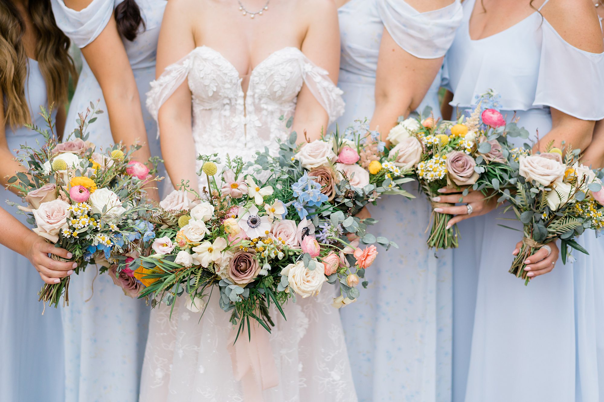 bride and bridesmaids hold garden inspired wedding bouquets