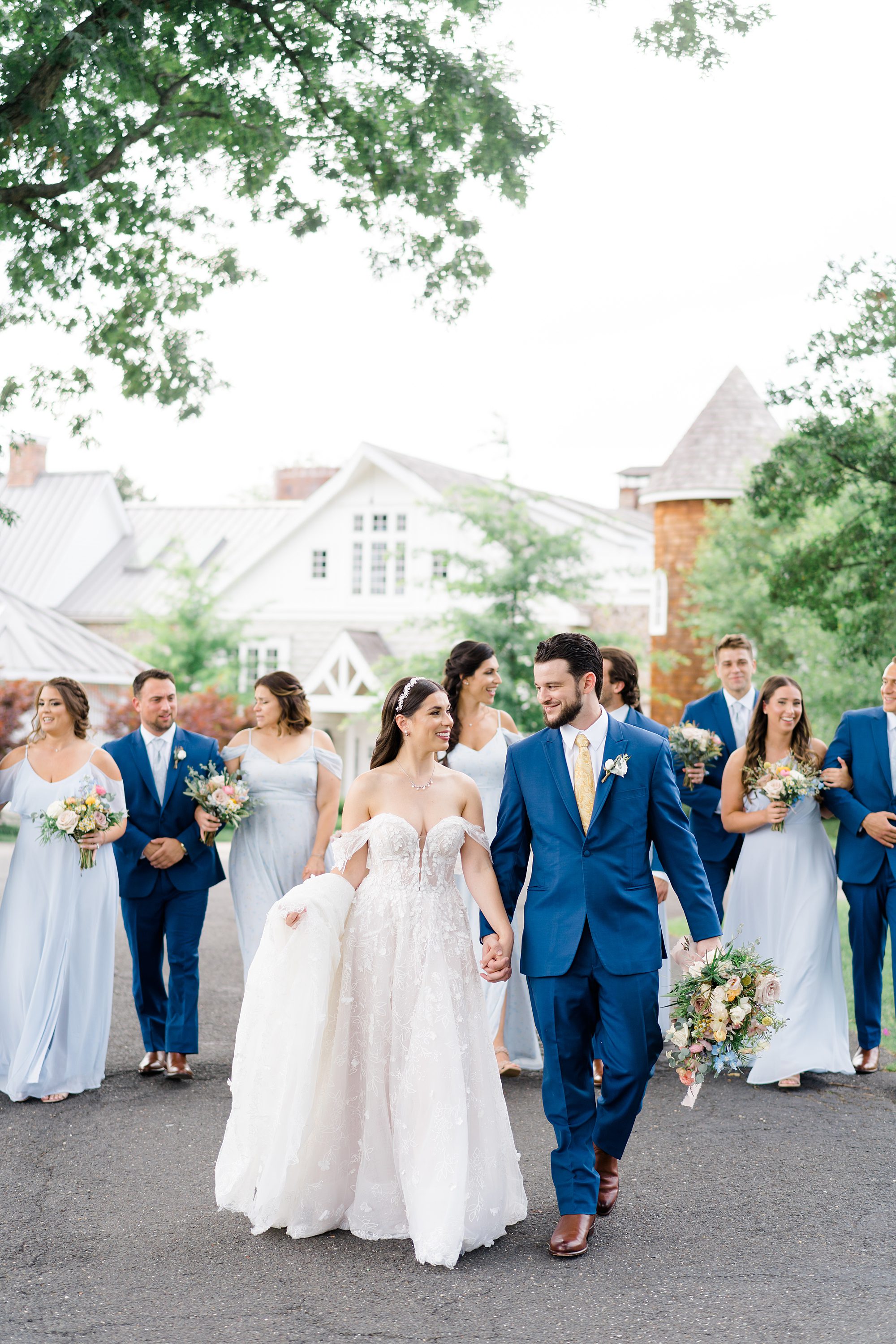 bride and groom walk with bridal party behind them