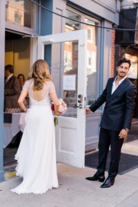 groom opens the door for his bride to restaurant Charley Dove