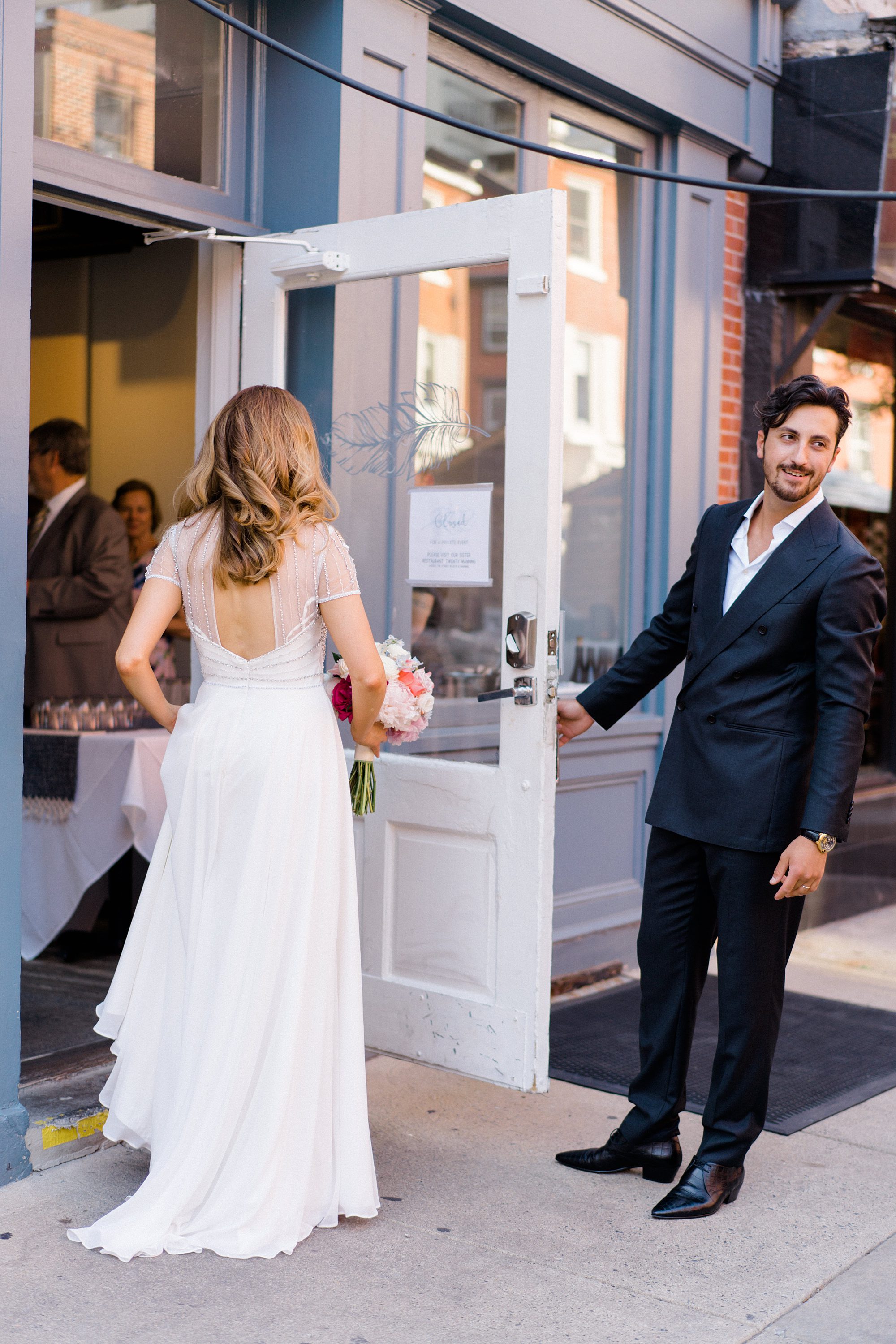 groom opens the door for his bride to restaurant Charley Dove