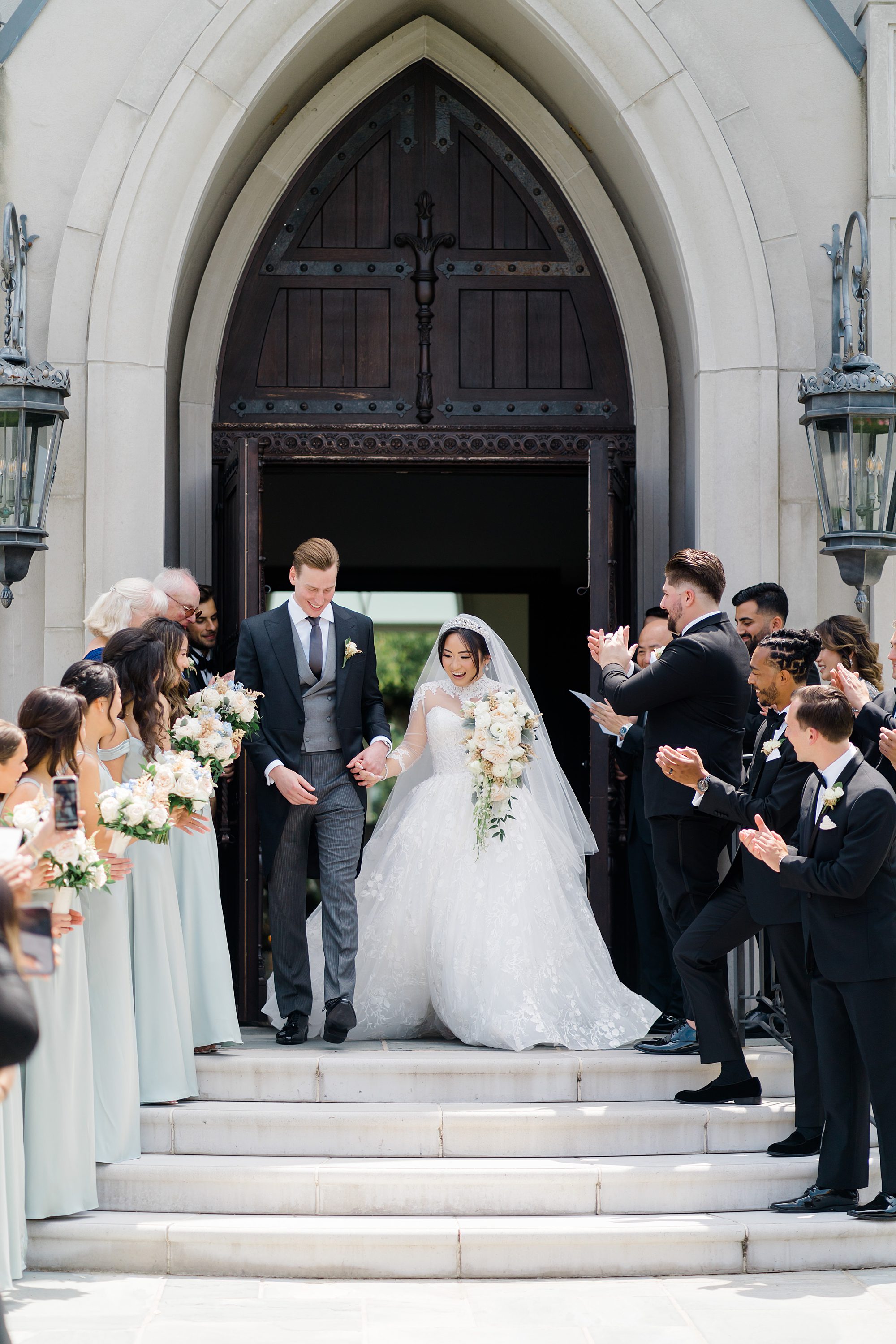newlyweds walk out of chapel with guests celebrating