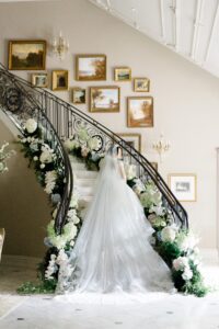 back of bride's wedding dress as she stands on winding staircase