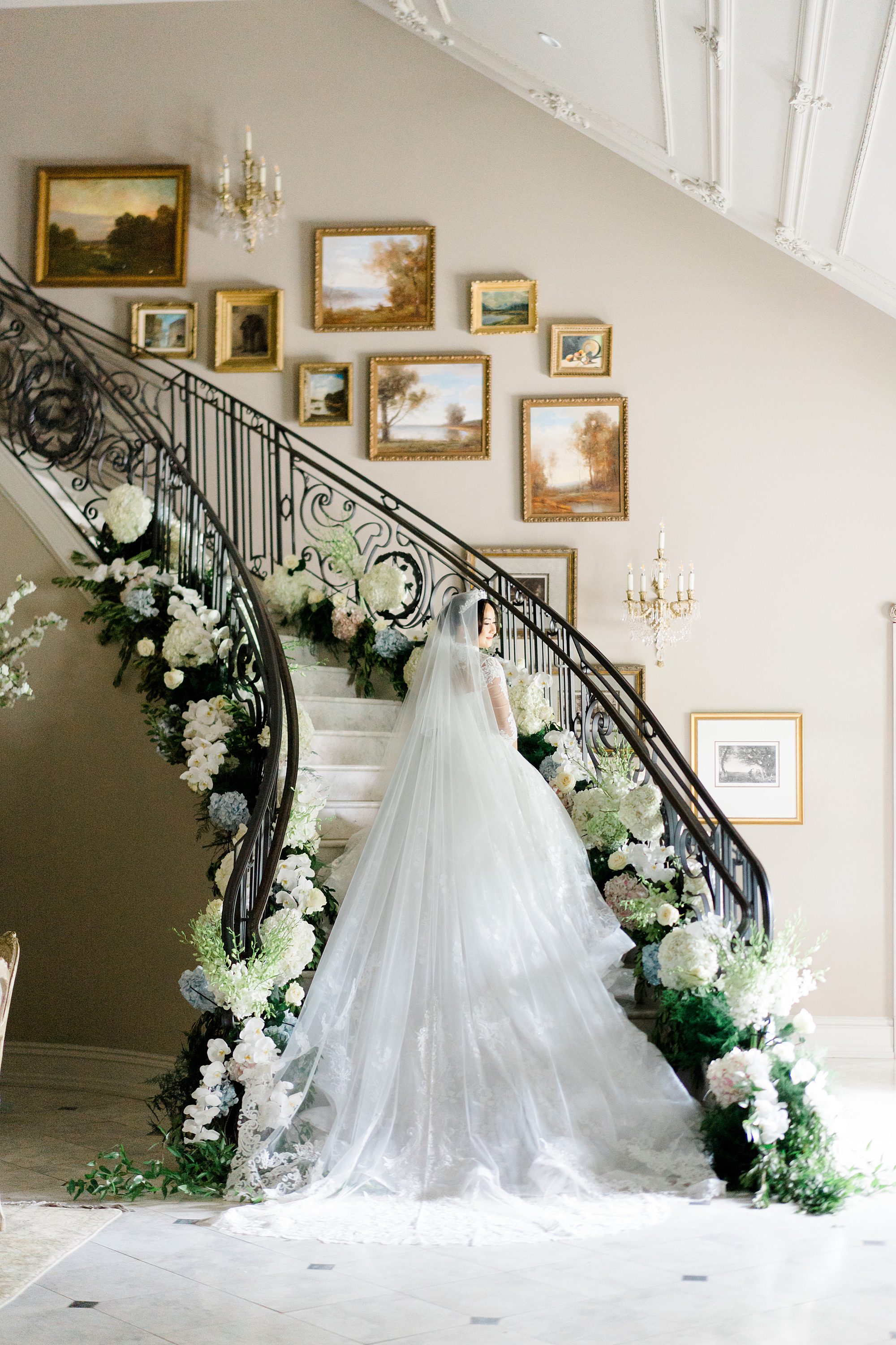 back of bride's wedding dress as she stands on winding staircase