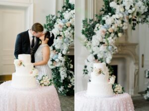 couple kiss by their classic three tier wedding cake