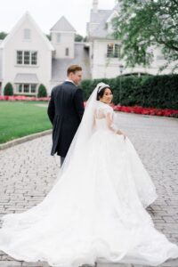 couple walk back towards elegant wedding venue at Park Chateau