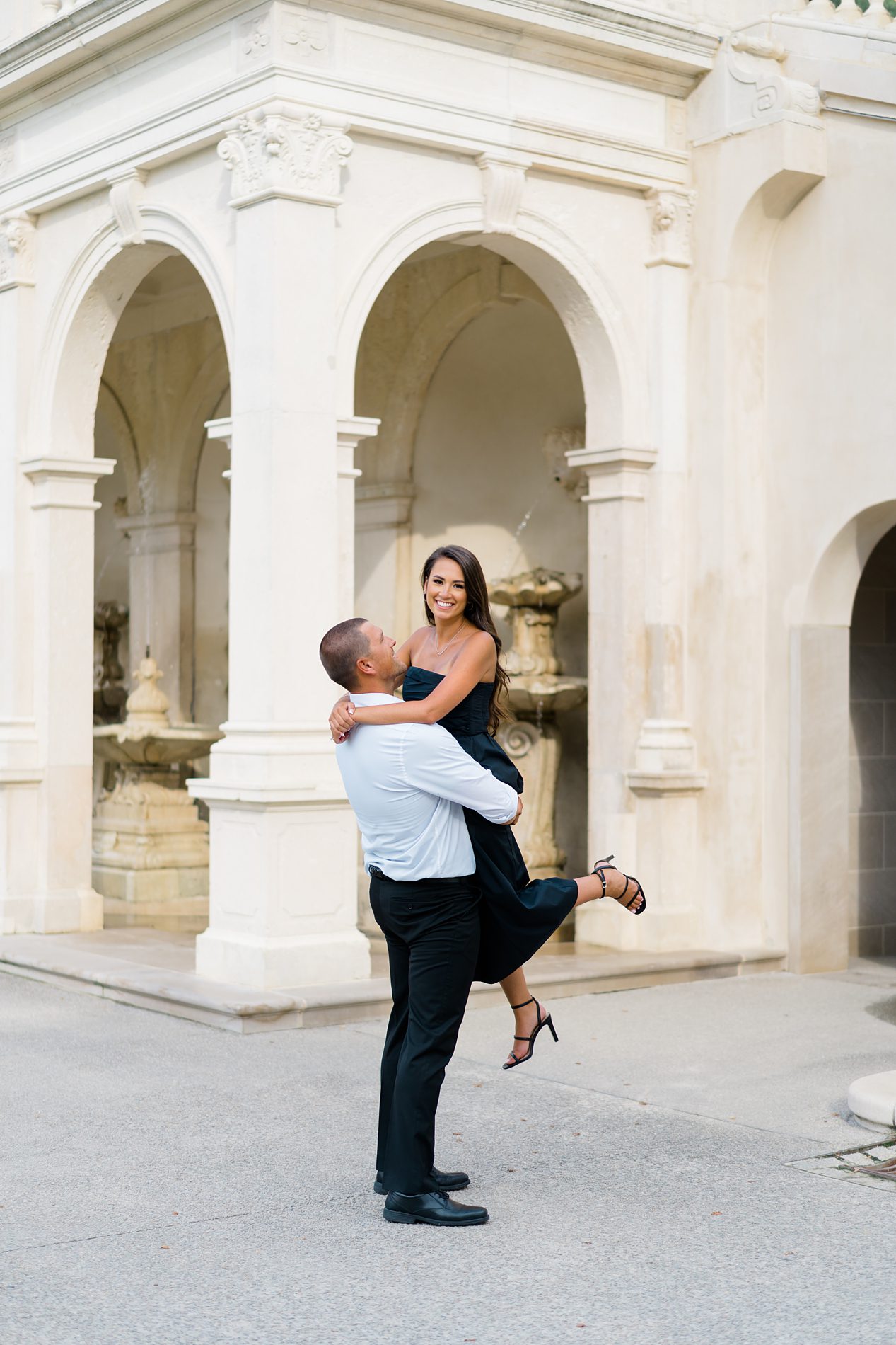man lifts up his fiancé during engagement session