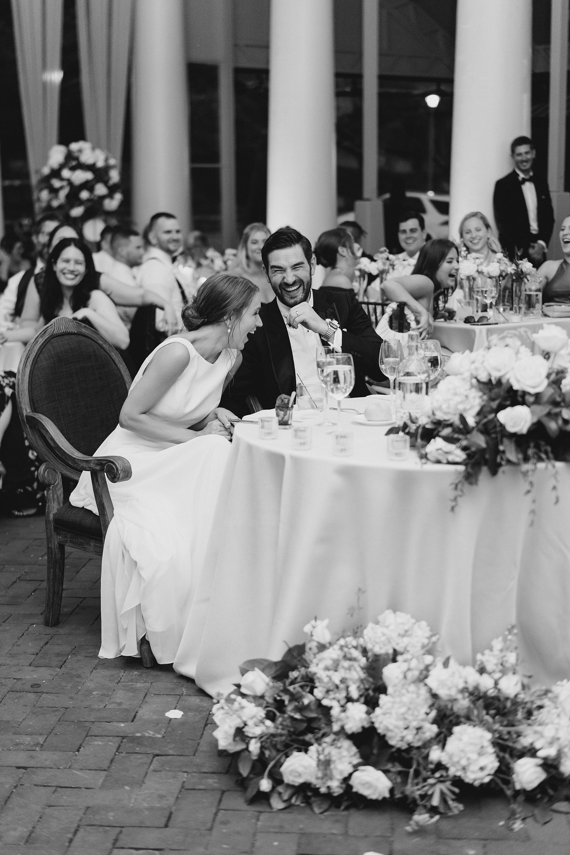 newlyweds laugh during wedding toasts