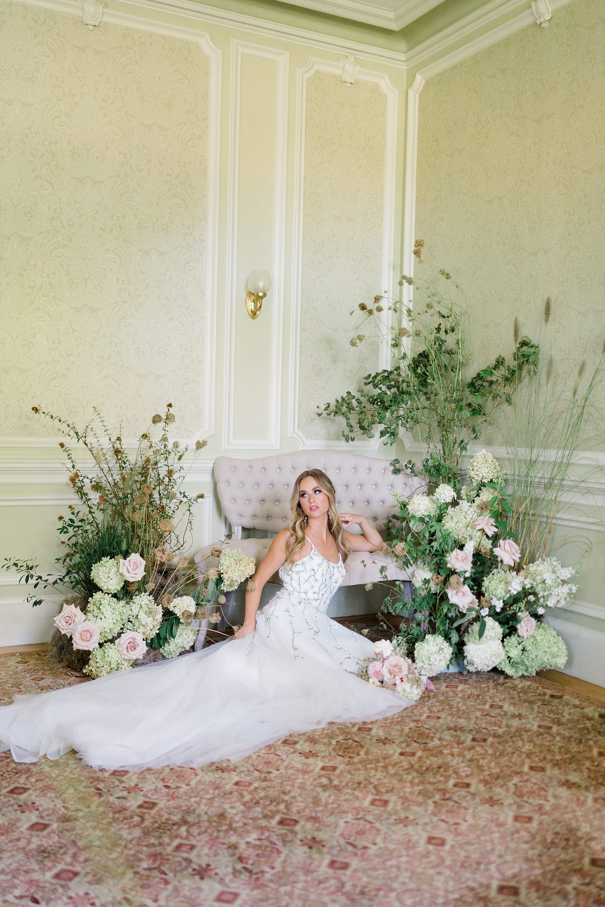 bride sitting on the floor surrounded by flowers