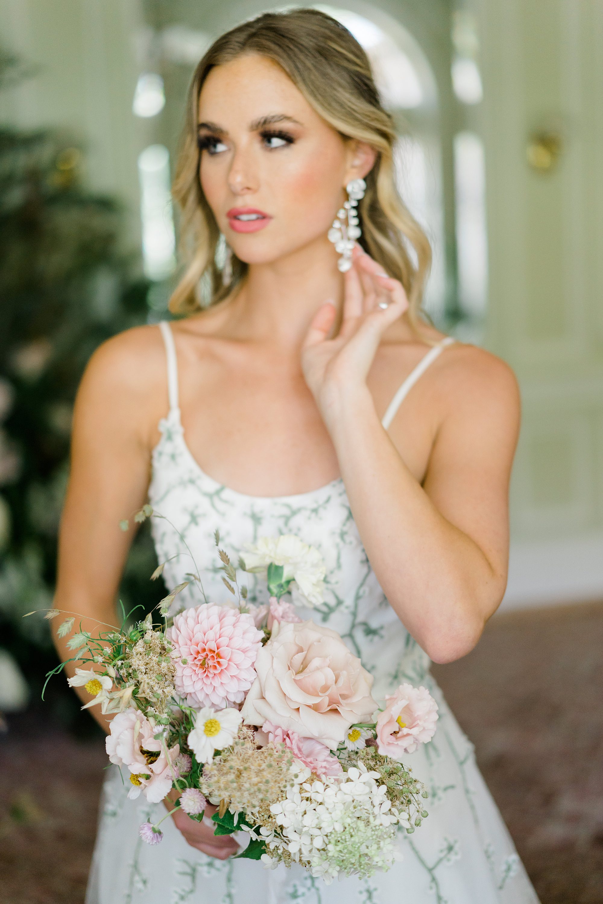 bride's earrings and wedding bouquet