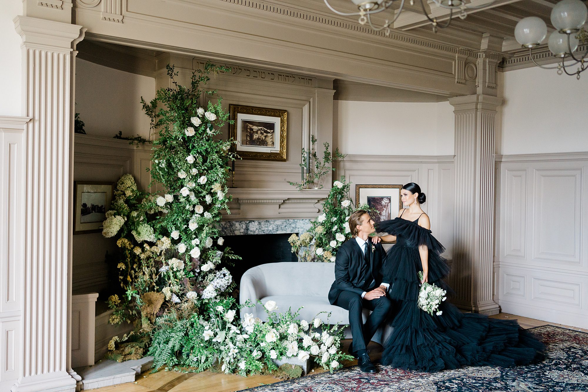 couple sit on couch in Cairnwood Estate during High Fashion Black Wedding Dress Styled Shoot