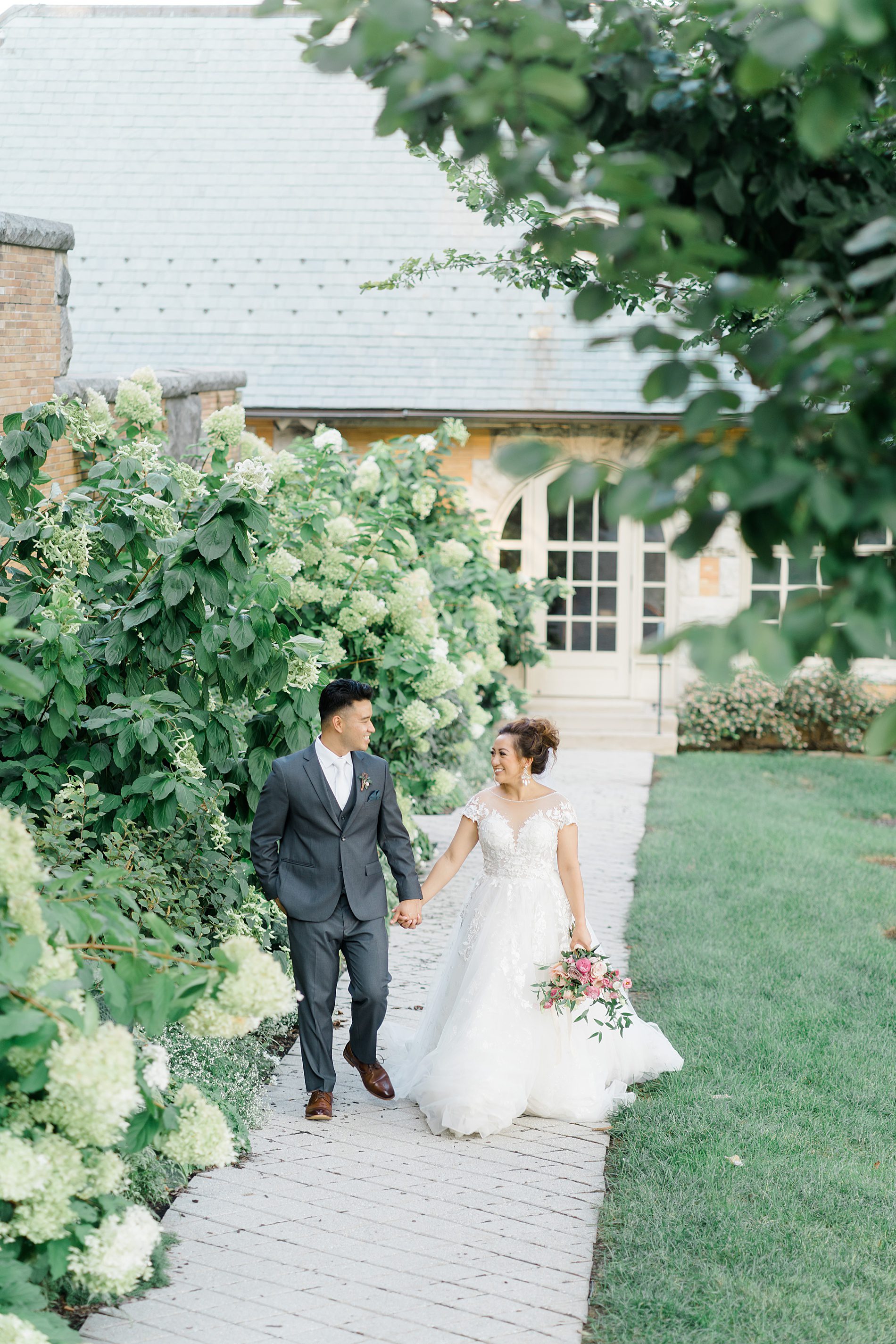 Bride and groom walk in the gardens