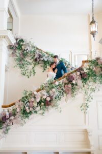 bride and groom stand in middle of stairs