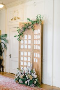 table seating chart using scrolls pinned to decorated wood