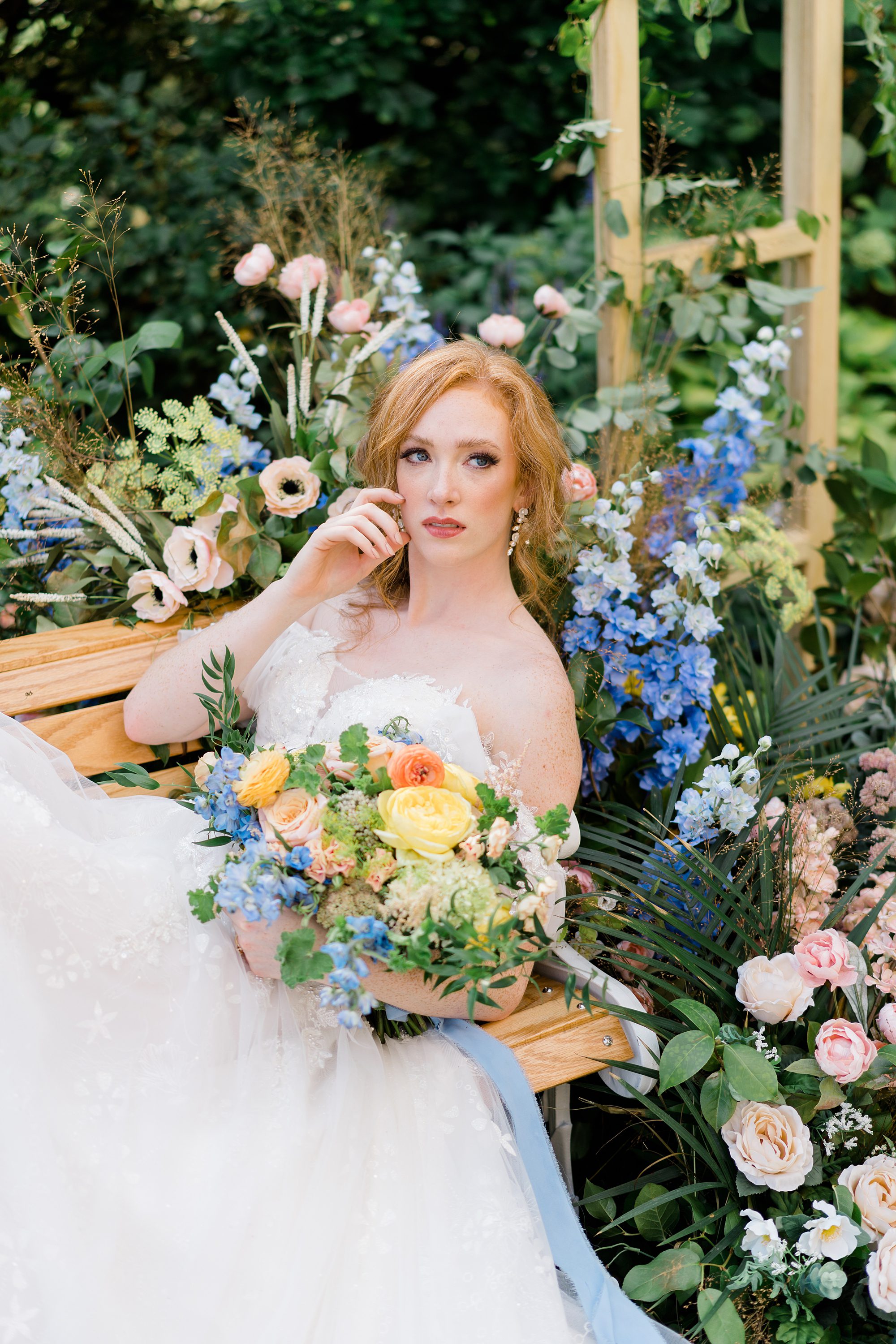 bride holding yellow and blue flower bouquet